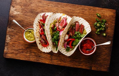 Fajitas de bistec a la parrilla con tortillas de taco y salsa, el origen de los tacos.