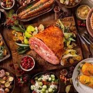 Un jamón de pavo acompañado de diferentes guarniciones navideñas.