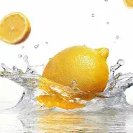 Un tipo de limón amarillo cayendo en el agua.