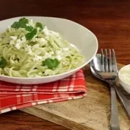 Pasta aromatizada con cilantro, servida en un plato blanco.
