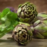 Tres alcachofas crudas y listas para cocinar.