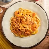 Plato de pasta con camarones, tomate, ajo y pimienta comida italiana   