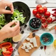 Aceite de oliva, queso, frutas cítricas y jitomates para una ensalada griega, una comida mediterránea.