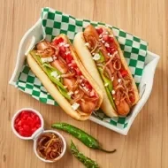 Plato con hot dogs, cebollas caramelizadas, jitomates y chiles 