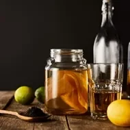 Frutas cítricas, botellas y vasos con kombucha 
