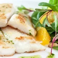 Pescado preparado en freidora de aire con una ensalada de hojas verdes.