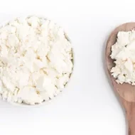 Queso casero en una cuchara de madera 