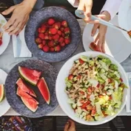 Mesa de picnic con ensalada con pasta y frutas