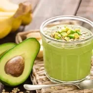 Aguacate partido a la mitad con un batido de cereal y verduras para desintoxicar el cuerpo.
