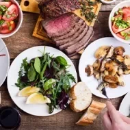 Mesa con comida y cuántas calorías se deben consumir al día según tus actividades y dieta.