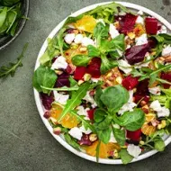 Ensalada en cenital con hojas verdes, remolacha, queso y frutos cítricos, un plato que puedes conservar en casa