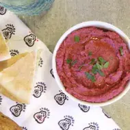 Recipiente con hummus de betabel con pan pita