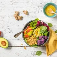 Plato con variedad de verduras y granos, receta de ensalada de aguacate