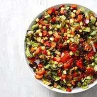 Una ensalada cremosa con maíz, tomate y aguacate en toma cenital