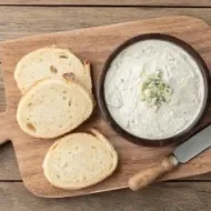 Tabla con rodajas de pan para esparcir salsa gorgonzola