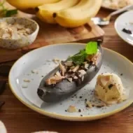 Plátano al horno entero y con cáscara, almendras y acompañado de helado, versión del dulce de plátano
