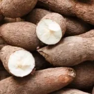 Montón de camotes apilados con dos de ellos cortados a la mitad.