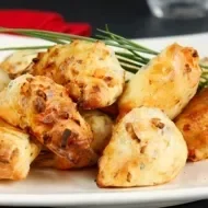 Plato lleno de buñuelos de bacalao recién cocinados.