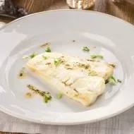 Filete de pescado blanco emplatado elegantemente.