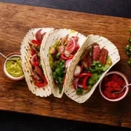 Tortilla de dieta llena de vegetales sobre tabla de picar. 