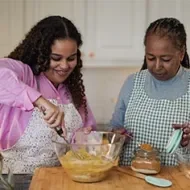Madre e hija se divierten horneando juntas en casa.