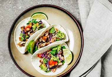 Tacos de cerdo. Tacos de cerdo en un plato sobre fondo gris, el origen de los tacos.